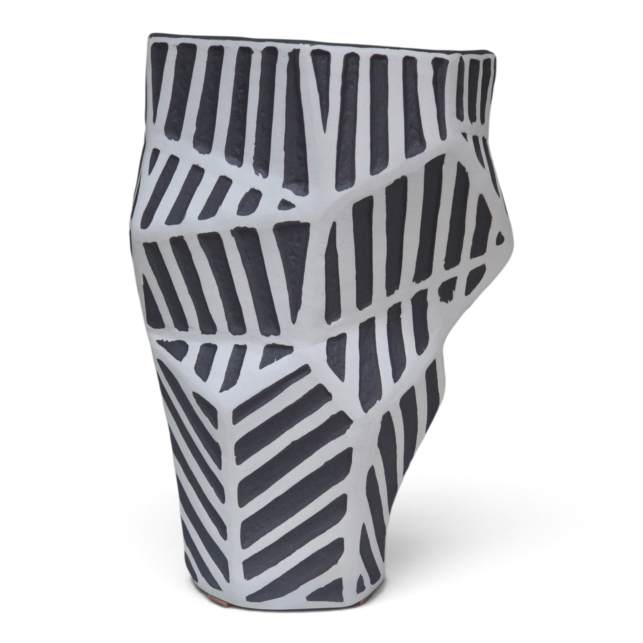 A sculptural ceramic planter with a textured, organic shape featuring a black and white geometric pattern of vertical and diagonal stripes.