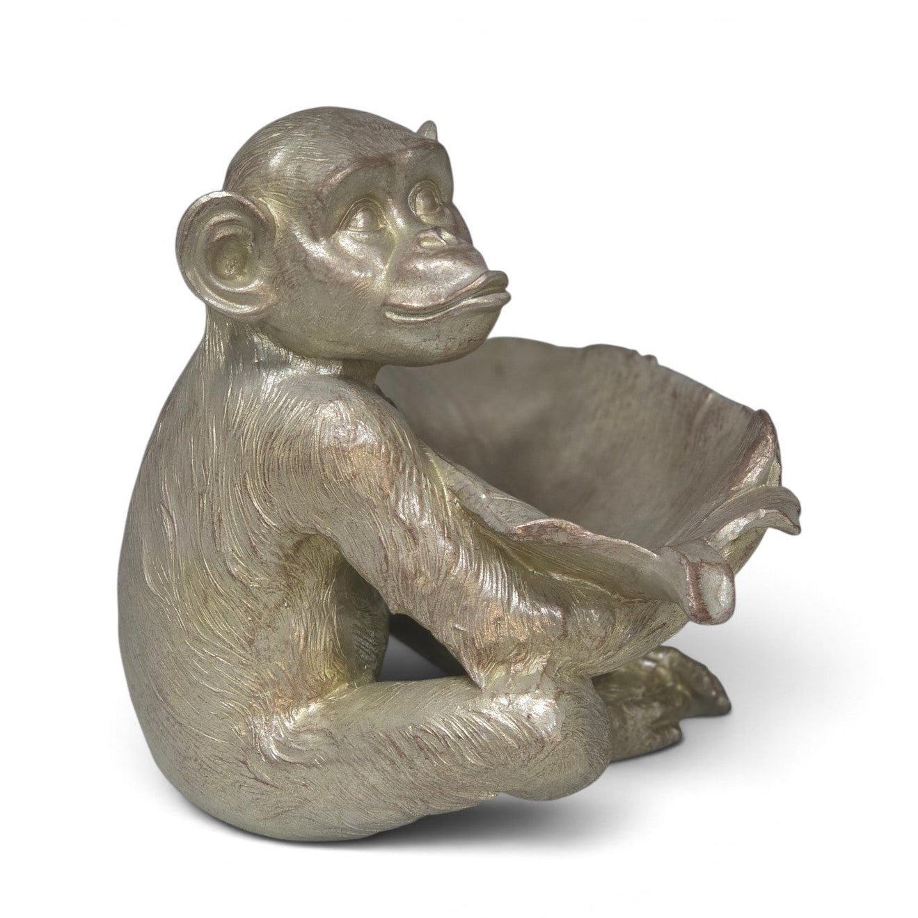 A metallic silver monkey figurine sitting in a seated pose with its arms extended, holding a large leaf-like shape, photographed on a clean white background.