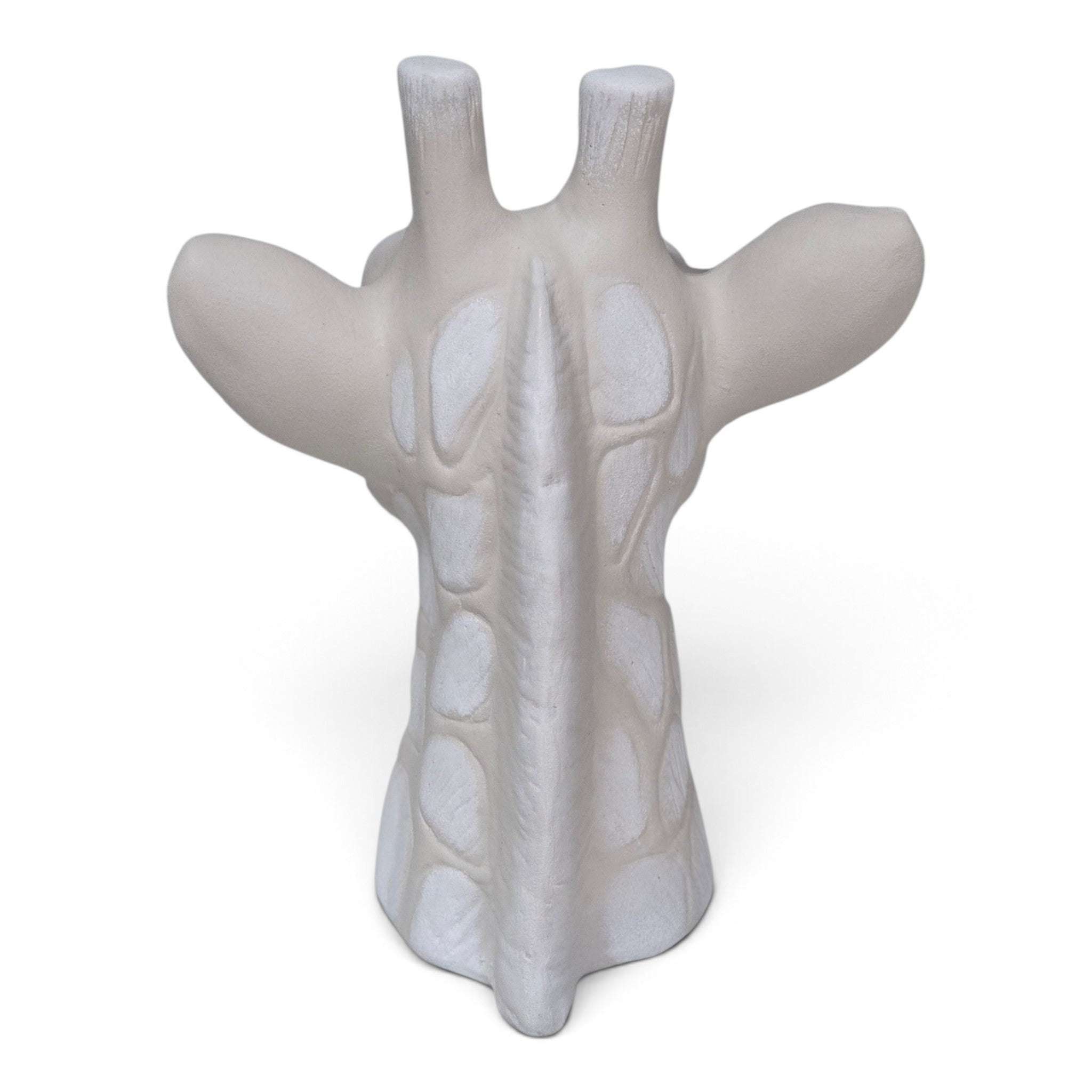 A white, sculptural giraffe head figurine with textured details, shown from the back against a plain white background.