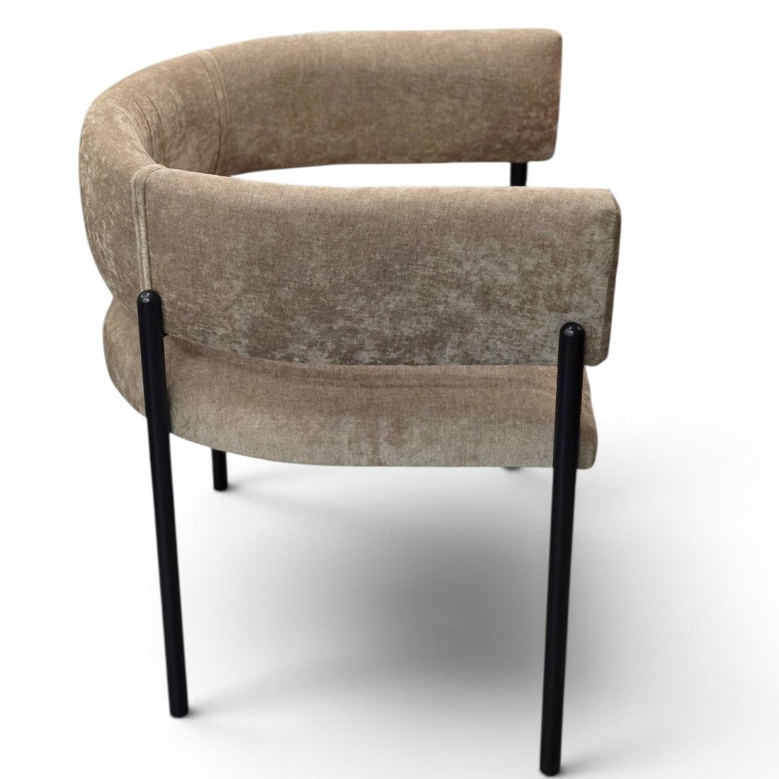 A modern curved armchair upholstered in a textured taupe velvet fabric with slim black metal legs, shown from a three-quarters angle on a white background.