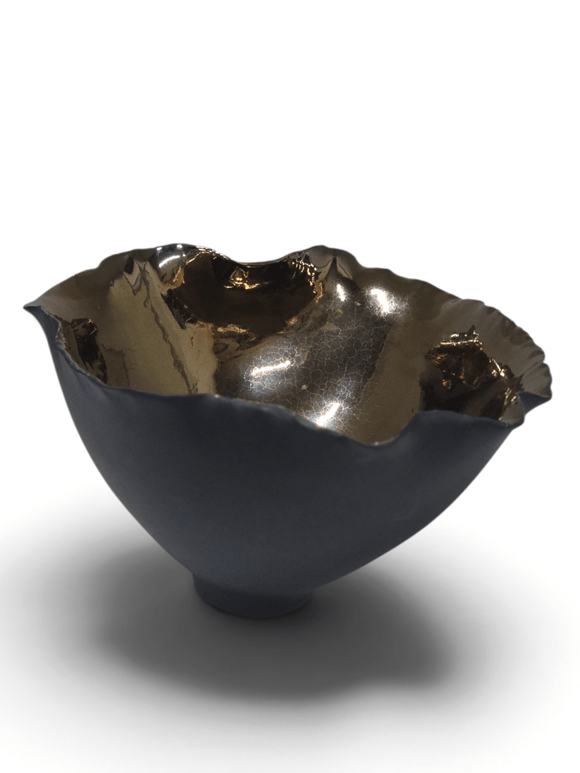 A metallic bowl with a dark, textured exterior and a hammered, reflective gold interior, shown on a clean white background with a soft shadow.