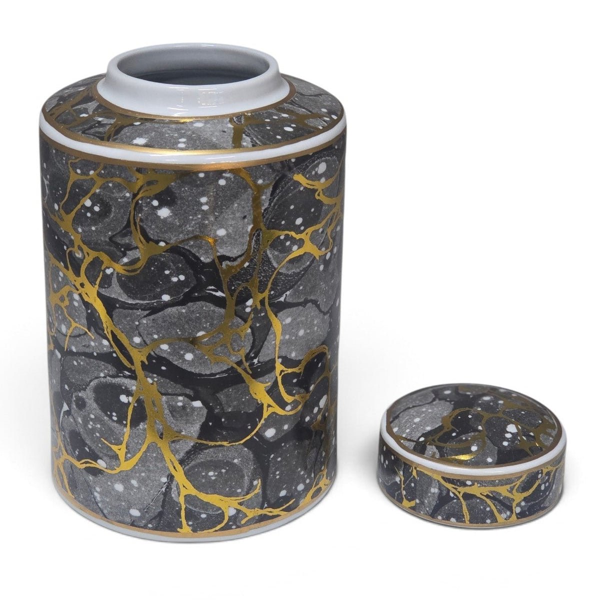 A cylindrical ceramic jar with a matching lid, featuring a black and gray marbled pattern with metallic gold veins and white speckles, set against a plain white background.