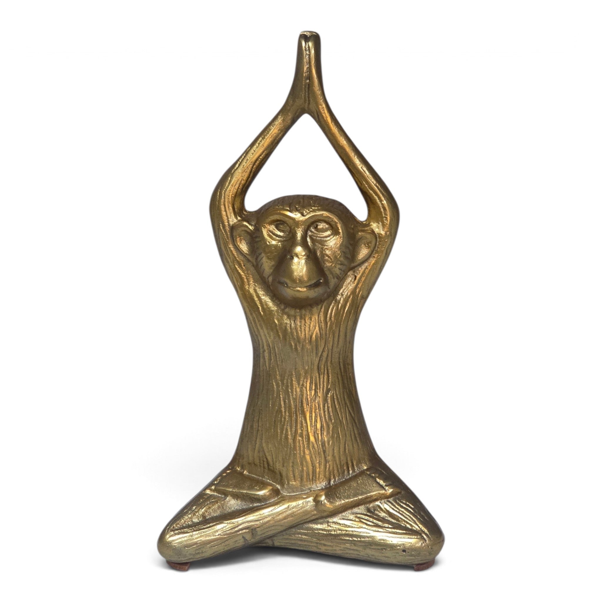 A small decorative figurine of a seated monkey with arms raised overhead in a yoga-like pose, finished in a metallic gold/brass tone against a plain white background.
